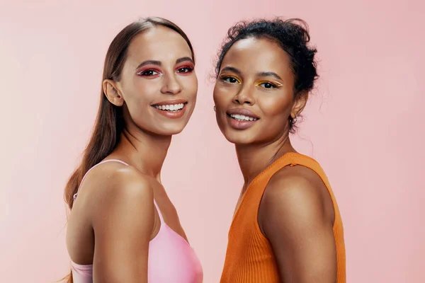 Stock image Woman beauty beautiful pink studio bodycare healthy colorful african eye girls mixed two model happy together portrait make-up skin american face attractive race care shine