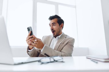 Ofis işadamı masasında oturuyor ve dizüstü bilgisayarda çalışıyor ve telefonla konuşuyor, modern takım elbise, finans ve başlangıç konsepti ve veri analizi, parlak bir ofiste çalışma tarzı. Yüksek kalite fotoğraf