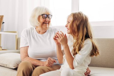 Mutlu bir kadın kanepe, mutlu bir torun, neşeli bir ev kızı, anne, yaşlı bir aileyi kucaklıyor, yaşlı bir torun, büyük anne, kanepede yaşlı bir kızı seviyor.