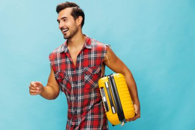 Erkek hafta sonu stüdyosu tatil bileti seyahat uzay yolculuğu yaşam tarzı mutlu bagaj hipster yolculuk mavi arka plan uçuş valizi adam sarı kopya trip valiz