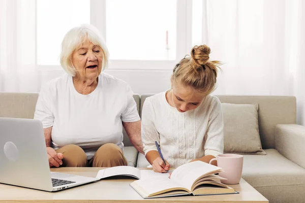 Bonding togetherness two laptop hugging child family education t-shirt grandmother copy call selfie people sofa smiling indoors video white photography granddaughter space