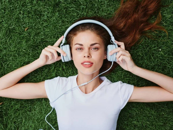 Mulher Fones Ouvido Ouvindo Música Sorrir Com Dentes Deitados Grama — Fotografia de Stock