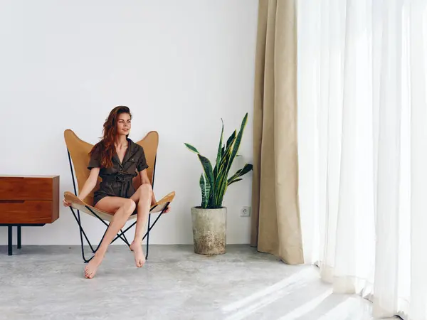 Mujer Sentada Una Silla Cerca Ventana Sonriente Interior Moderno Elegante —  Fotos de Stock