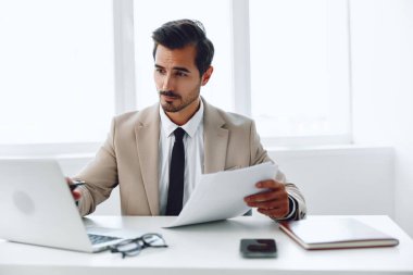 Yakışıklı gözlüklü lider, iş elbisesi planlama, dizüstü bilgisayar çekici iş adamı ofisini mutlu eden kağıt kazananı tutuyor.