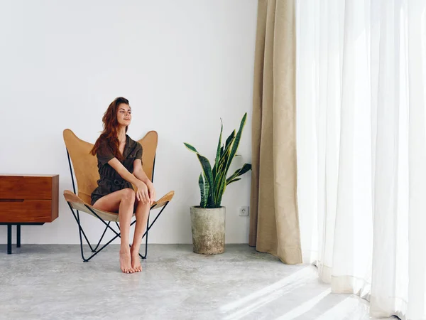 Mujer Sentada Una Silla Cerca Ventana Sonriente Interior Moderno Elegante —  Fotos de Stock