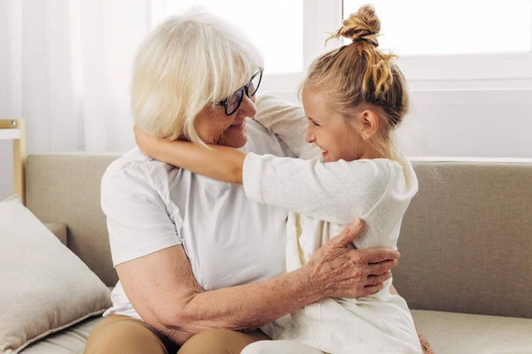 母を抱きしめる女性は祖母のライフスタイルを愛する少女 幸せなハグ ソファー ソファー — ストック写真