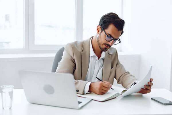 Suit white businessman entrepreneur smiling holding looking office caucasian document company planning using laptop corporate handsome paper male attractive happy
