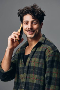 Erkek yaşam tarzı soyutlanmış arka planda duruyor mavi gülüyor mutlu telefon, gri, şık stüdyo ciddi, güzel, beyaz saçlı beyaz tişört.