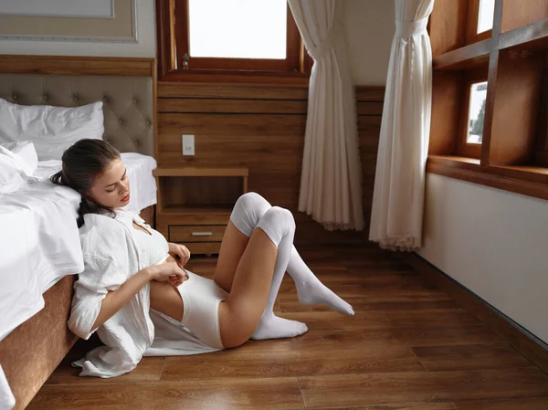 年轻性感的女人早上坐在床边 休息一天舒服的在家里 舒适的内衣 带着微笑的度假生活 高质量的照片 — 图库照片