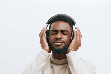 Afrikalı yakışıklı adam, çekici arka plan müziği, Amerikan stüdyosu, Amerikan tarzı, mutlu baş bej rengi, siyah, renkli kulaklıklar, DJ tarzı hayat tarzı.