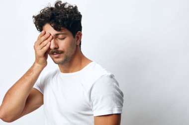 Siyah, çekici sakallı bir adam beyaz bir moda öğrencisi tişörtü soyutlamış ciddi, ayakta duran, kendine güvenen bir hippi portresi.