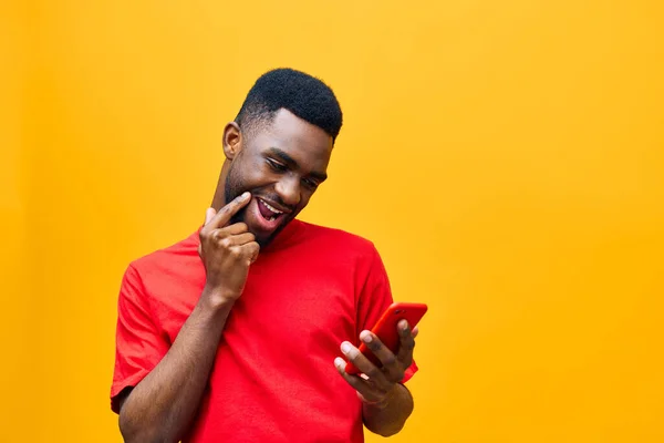 isolated man african mobile background young phone studio typing phone technology yellow cyberspace mobile hipster internet happy message black red millennial business trendy