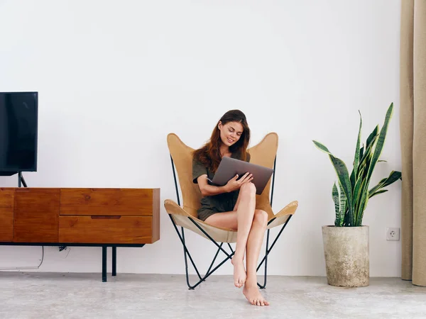 女学生坐在椅子上 带着笔记本电脑 在家里笑着放松一下 现代时髦的斯堪的纳维亚内部生活方式 复制空间 高质量的照片 — 图库照片