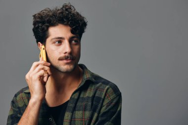 Adam gülümseyen beyaz model mutlu yaşam tarzı ifade stüdyosu ciddi portre sıradan tarz çekici siyah arka plan telefon gri teknoloji moda eli