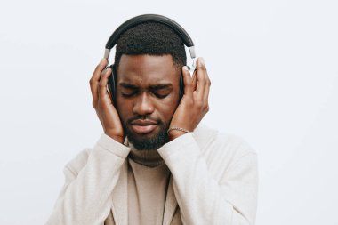 Afrikalı adam Afrika müziği siyah moda Amerikan renkli portre DJ gözlükleri dişleri beyaz afro yüz kulaklıkları gri Afrika bej yakışıklı arka plan pozitif
