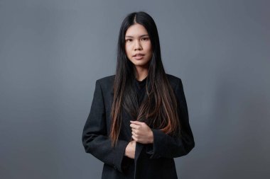 Şık bir gülümseme modeliyle güzel bir palto güzel bir stüdyo gri cazibeli saçlar kışın esmer bir portre şirin bir moda kızı Asya sonbahar tarzı