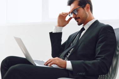 Ofisteki genç iş adamı dizüstü bilgisayarda çalışan profesyonel kişi kazanan yönetici duygusal sandalye teknolojisi iş portresi başarılı adam kazanmaktan mutlu.