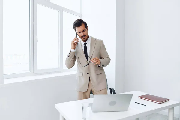 Mobile man phone connection wireless phone technology laptop businessman computer glasses smile document winner office happy desk talk smartphone suit video call call