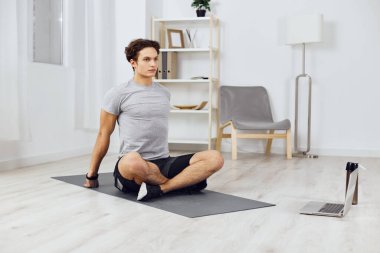 Spor adamı içeride oda aktivitesi kaslı ev hobisi gri ev erkek ev tipi dizüstü bilgisayar aktif halterli sağlık eğitimi egzersizi
