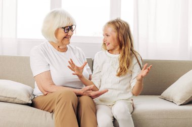 Aşk kadını, aile torunu kız torun, büyükanne, yaşlı torun, yaşlı ev, yaşlı ev, kucak, mutlu ev çocuğu, anne-kız kanepe, kanepede yatar.
