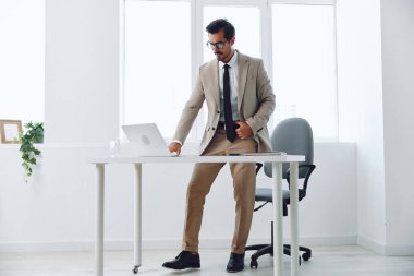 Mutlu görünen erkek işçi, dizüstü bilgisayar masasında oturan erkeklere uyar. Girişimci ofiste iş adamı diye bağırır. İş dünyasının kazananı ifadesi, evet arka plan teknolojisi yaşam tarzı duygusu kazanır.