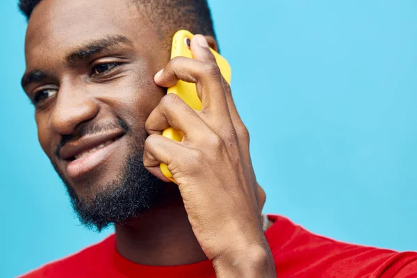 mobile man lifestyle background happy technology african showing phone portrait young smartphone isolated black cellphone millennial model excited person smile cyberspace blue