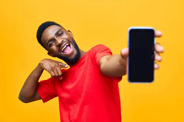 man phone background yellow technology app black blank hand studio cellphone model mobile african happy person smile young smartphone excited cyberspace millennial