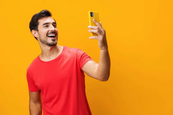 Pointing man technology smiling studio yellow lifestyle phone toothy isolated eyeglass copy smartphone surprise happy business smile mobile cyberspace message phone space communication portrait
