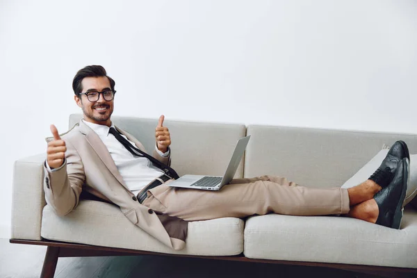 Networking man couch looking lifestyle business call working laptop communication handsome success watching cozy home online computer using casual smiling portrait guy sofa video relaxed