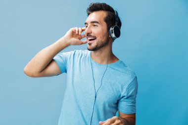 Duygu adamı yaşam tarzı stüdyo portresi mutlu arka plan çevrimiçi eğlence fotokopi eğlenceli müzik alanı tişörtlü konuşan mavi kulaklıklı adam şarkı söylerken keyfini çıkar