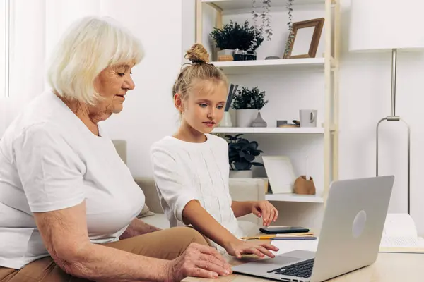 Education grandmother bonding photography people laptop hugging copy selfie call sofa space t-shirt smiling white video indoors togetherness child family granddaughter two