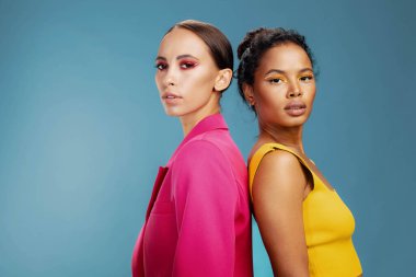 Güzel bir kadın, beyaz tenli, melez bir kızla ilgilenir. Çekici, sarı Afrikalı, mutlu, güzel, sağlıklı iki portre, Amerikan yüz modeli vücut bakımı stüdyosu derisi.