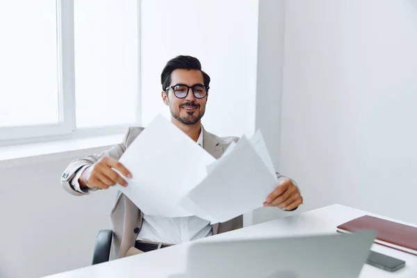 Man holding smiling suit planning positive executive success smart manager attractive happy paper modern laptop office professional document lifestyle looking businessman glasses company