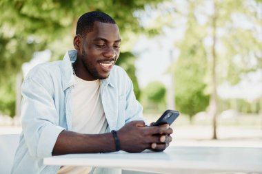 Genç cep telefonu yaşam tarzı gündelik akıllı telefon açık hava internet teknolojisi telefonu erişkin erkek erkeği dışarıda yakışıklı tutuyor.