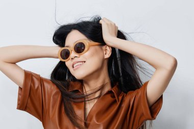 Güneş gözlüklü kadın çekici modellik seyahat sevimli Asyalı yüz çekici saç stili tatiller güzellik şapkası makyaj bej portresi