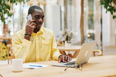 Bir kişi erkek iş adamı mobil ofis internet üzerinde çalışıyor modern yetişkin portresi dizüstü bilgisayar genç masa teknolojisi telefonda konuşuyor