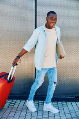Erkek yaşam tarzı yakışıklı turist Amerikalı gezgin yetişkin havalimanı turizmi çantası çantasıyla gezen modern erkek bavulu genç.