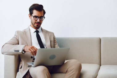 Kafkas erkek dizüstü bilgisayar serbest iletişim yakışıklı bilgisayar evde oturup video işi kanepesi başarılı genç gülümseyen ağ kanepede online yaşam tarzı