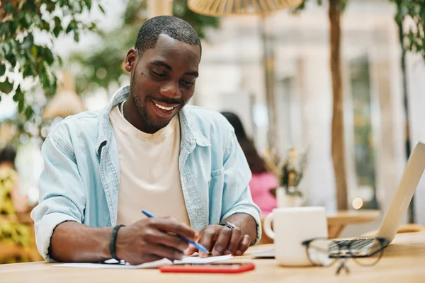 Man young person black student sitting adult portrait lifestyle african work education business looking male computer happy notebook table technology laptop communication businessman