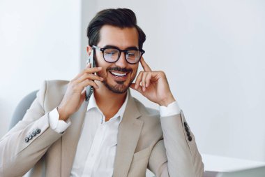 Adam gülümse ofis genç iş adamı telefon bej konuşma kazananı bilgisayar arama teknoloji video iş elbise kurumsal laptop işçi cep telefonu