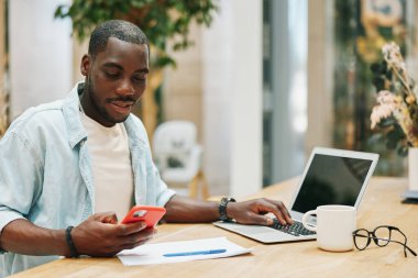 Erkek masasında çalışan Afrikalı siyah telefon yaşam tarzı modern portre yetişkin dizüstü bilgisayar işadamı iş adamı genç teknoloji oturan kişi