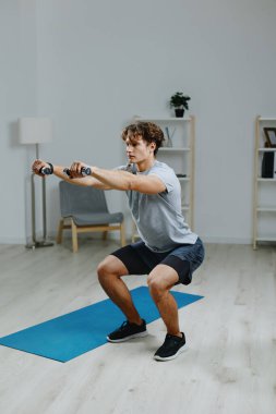 Erkek dambıllar yaşam tarzını eğitiyor ev sağlığı aktivitesi gri iç mekanda fiziksel kol kası güçlü karın kasları aktif spor spor fitness aktif dizüstü bilgisayar sağlığı egzersizi