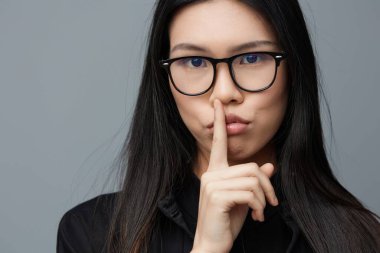 Şirin, mutlu bir öğrenci stüdyo yaşam tarzını işaret ediyor arka plan güzelliği Asyalı moda işi neşeli, güzel bir portre parmağı gülümsemesi çekici kız modası