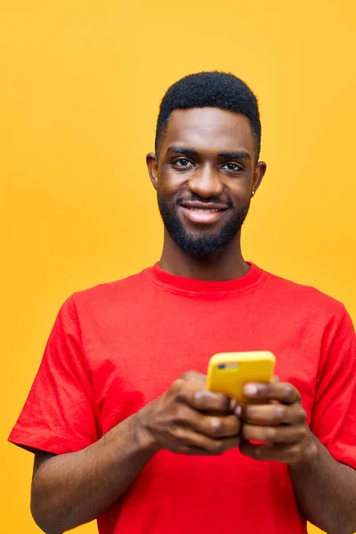 background man red screen young adult african mobile portrait online technology yellow model isolated studio smartphone happy person phone black afro cell