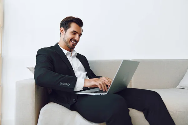 Person man desk job successful smile smart workplace indoors male office white businessman call suit working sitting video caucasian using sofa room professional laptop