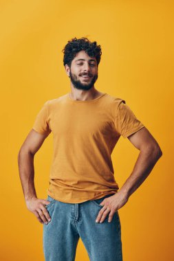 Adam stüdyoya bakıyor beyaz arka planda yetişkin jesti kendinden emin gülümseme izole edilmiş mutlu görünümlü genç İspanyol neşeli ifade sarı portre