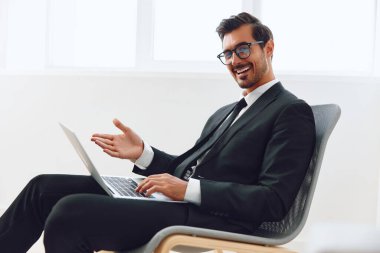 Laptopçu işyeri heyecan verici sandalye mutlu girişimci teknoloji işi evet oturan pozitif işçi ofisi genç iş adamı başarılı