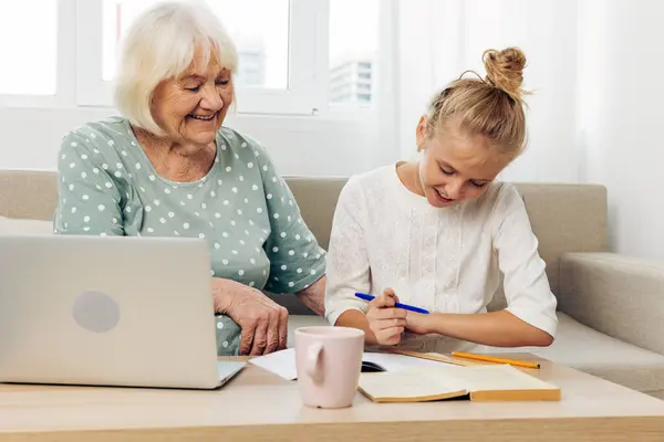 Family laptop t-shirt photography call smiling happiness togetherness space people adult hugging grandmother video white indoors granddaughter child selfie copy bonding senior two sofa education
