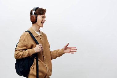 Melodik Anlar: Modern Müziğin Neşesini Neşeli, Şık Genç Adam Kablosuz Kulaklıklarından Hoşlanıyor