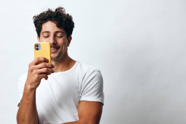 Adam telefon mankeni ayakta selfie tutuyor, noel portresi hipster mesajı cep telefonu İspanyol iş adamı ifadesi yaşam tarzı beyaz tişört teknolojisi.